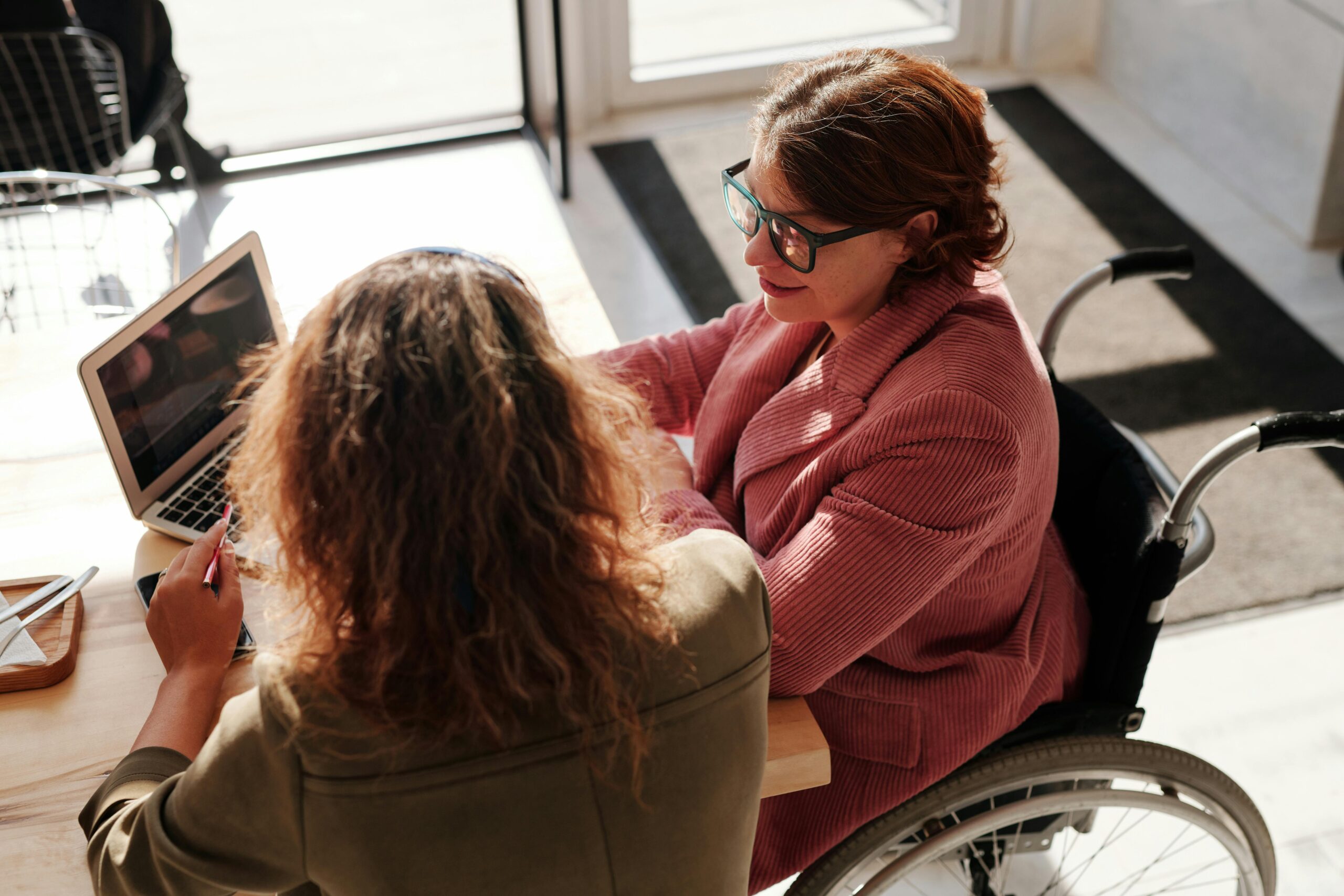 A woman in a wheelchair talking to another woman